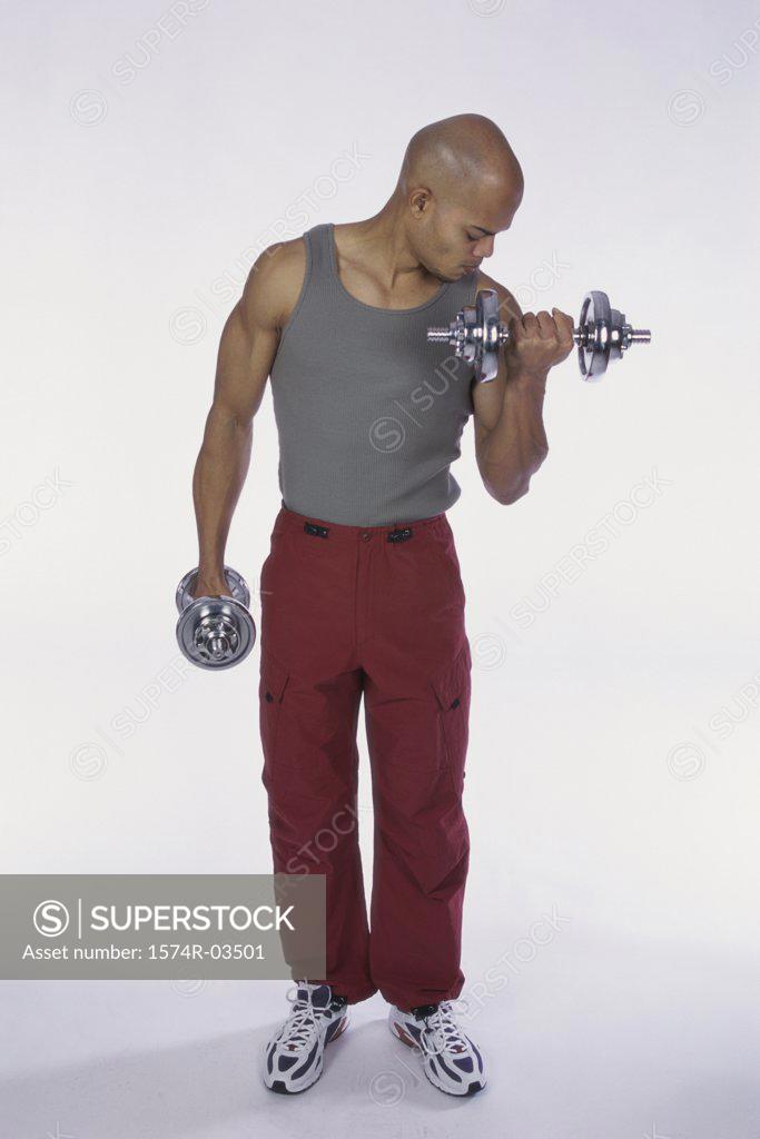 Stock Photo: 1574R-03501 Young man exercising with dumbbells
