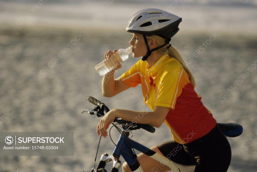 Stock Photo: 1574R-03504 Young woman drinking from water bottle