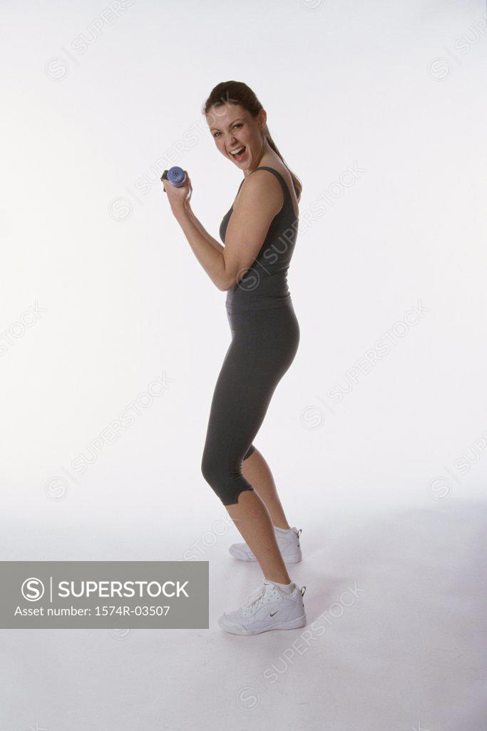 Stock Photo: 1574R-03507 Portrait of a young woman exercising with dumbbells