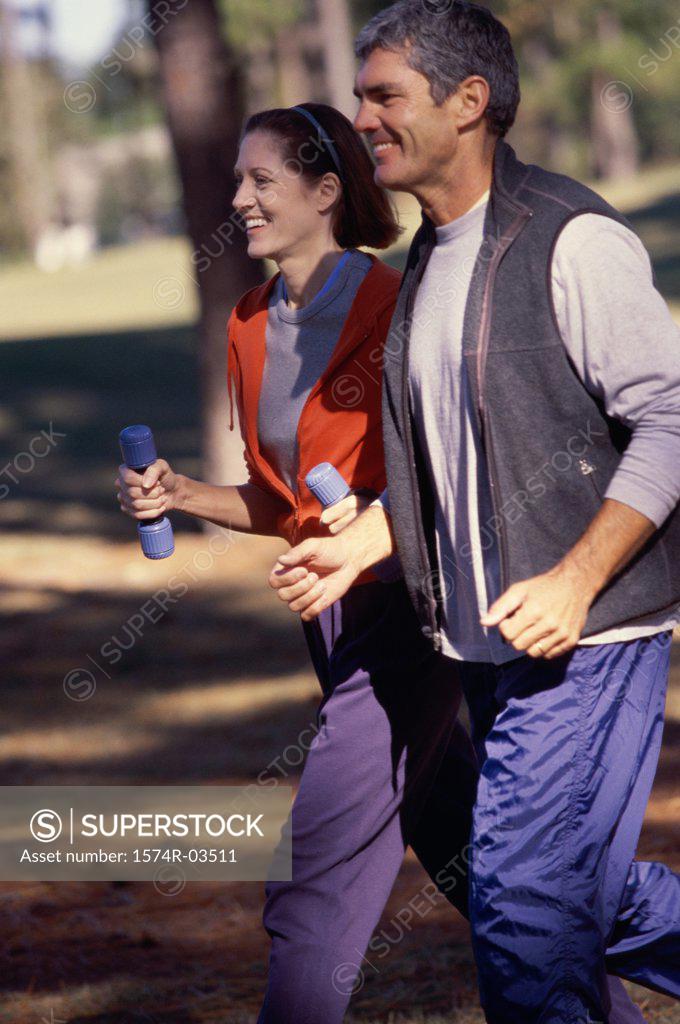 Stock Photo: 1574R-03511 Side profile of a mid adult couple jogging together