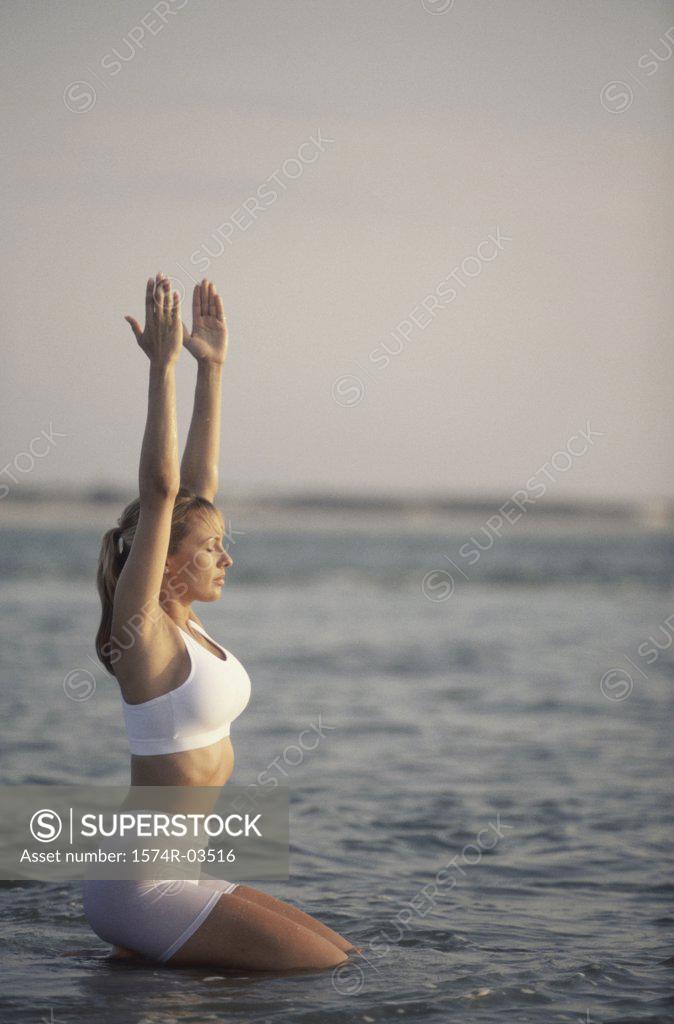 Stock Photo: 1574R-03516 Young woman exercising on the beach