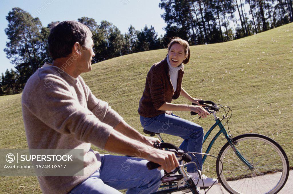 Stock Photo: 1574R-03517 Mid adult couple riding bicycles