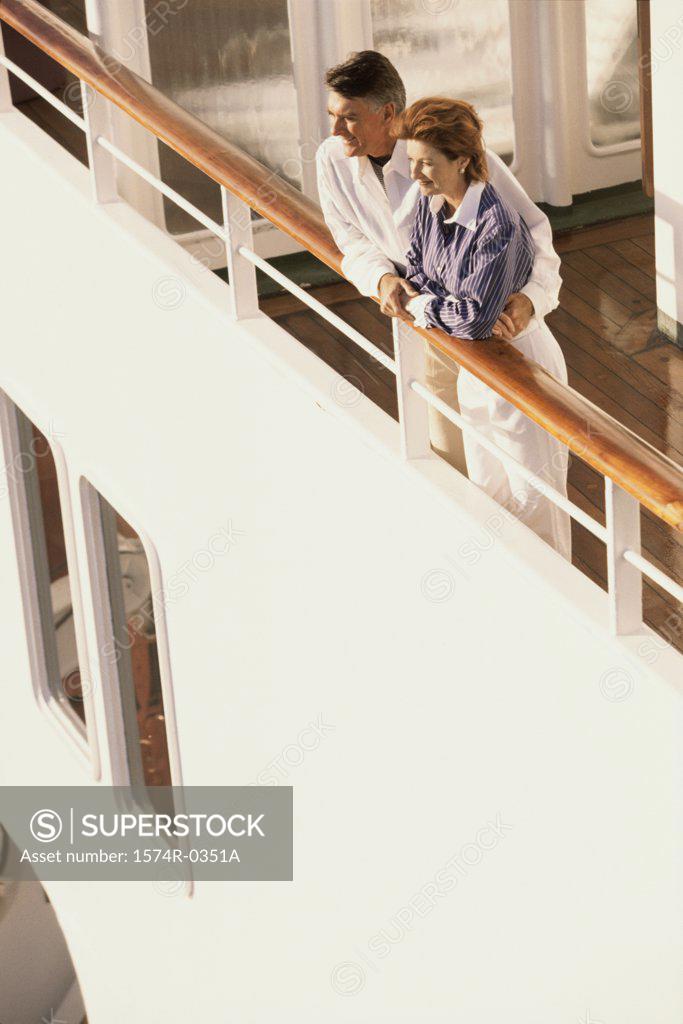 Stock Photo: 1574R-0351A Couple standing against the railing of a ship