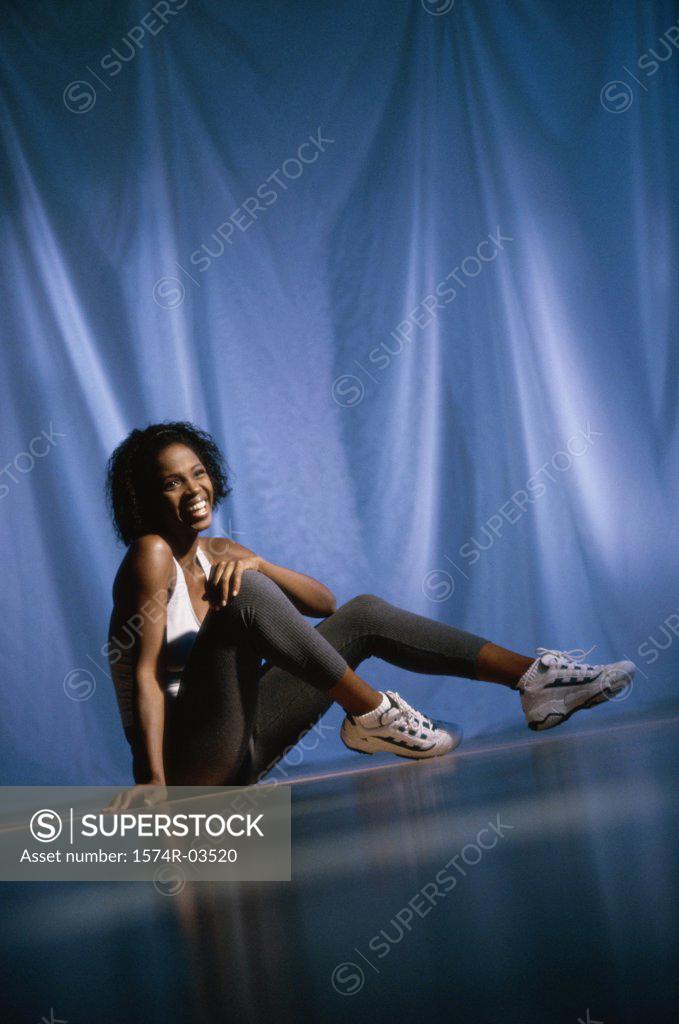 Stock Photo: 1574R-03520 Young woman smiling sitting on the floor