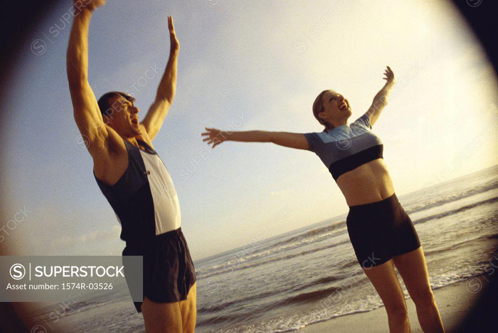 Stock Photo: 1574R-03526 Mid adult couple exercising on the beach