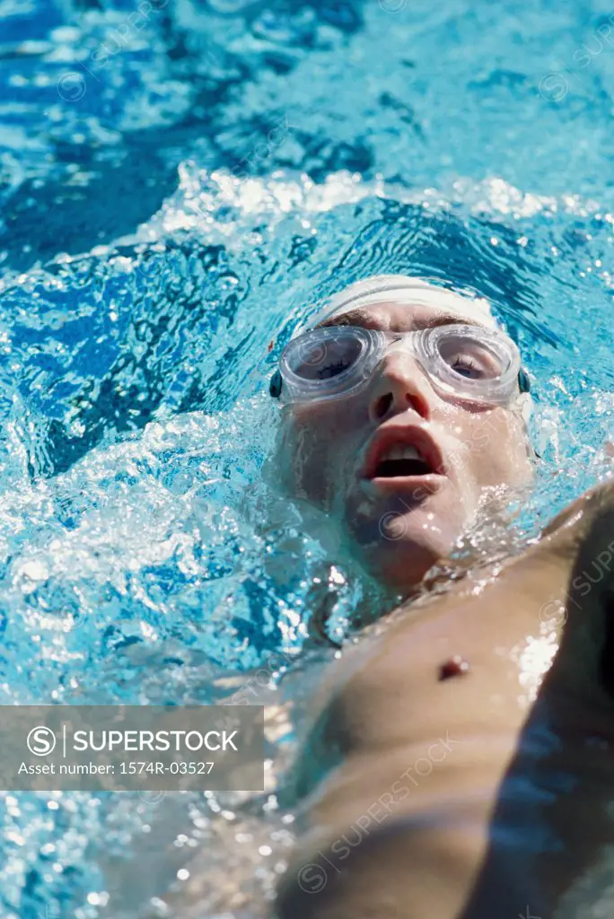 High angle view of a young man swimming the backstroke