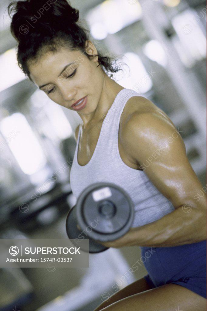 Stock Photo: 1574R-03537 Young woman exercising with dumbbells
