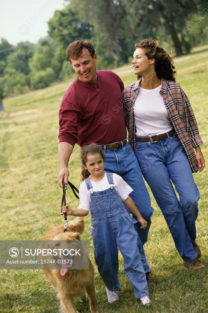 Stock Photo: 1574R-03573 Parents walking with their daughter and a dog