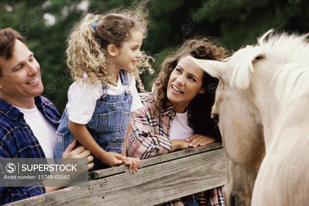 Stock Photo: 1574R-03582 Parents with their daughter in front of a horse