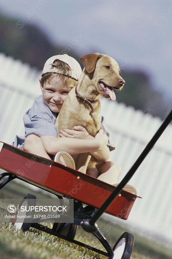 Stock Photo: 1574R-03589 Portrait of boy sitting in a toy wagon holding his dog