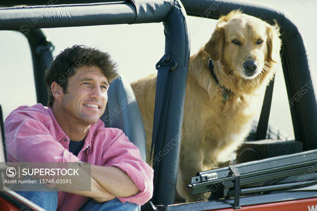 Stock Photo: 1574R-03591 Mid adult man sitting in a jeep with his dog