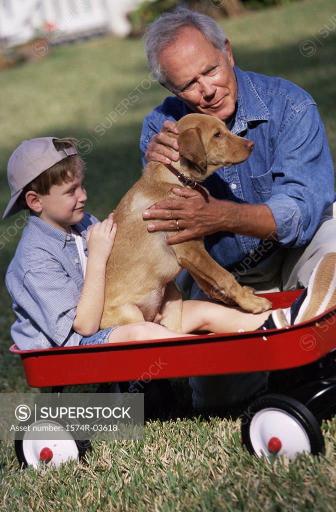 Stock Photo: 1574R-03618 Grandfather and his grandson holding their dog