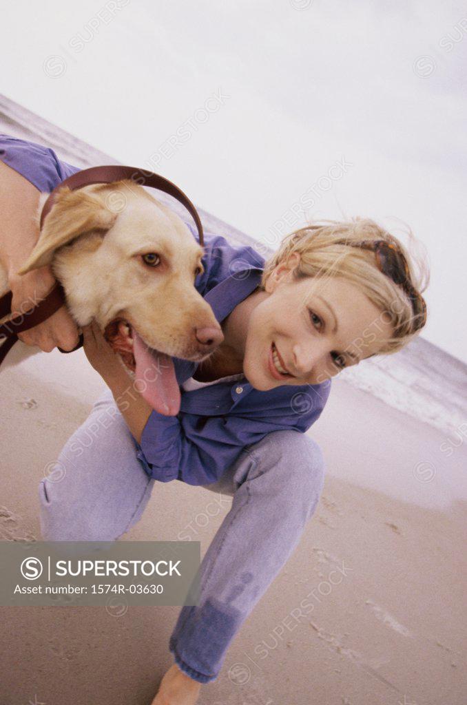 Stock Photo: 1574R-03630 Portrait of a young woman with her dog on the beach