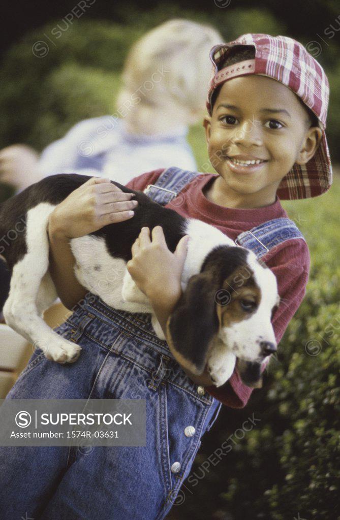 Stock Photo: 1574R-03631 Portrait of a boy holding a puppy