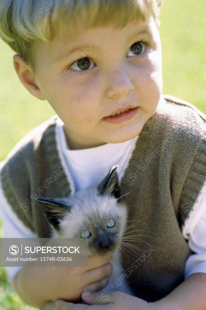 Stock Photo: 1574R-03636 Close-up of a boy holding a Siamese kitten