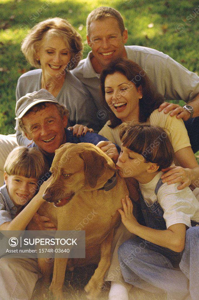 Stock Photo: 1574R-03640 Portrait of a family sitting together on a lawn with their dog