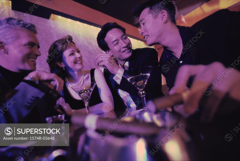 Stock Photo: 1574R-03648 Three mid adult men and a mid adult woman sitting in a bar