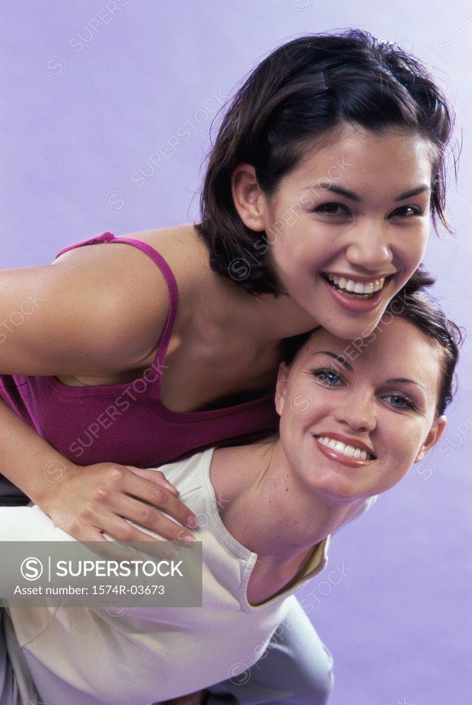 Stock Photo: 1574R-03673 Portrait of a young woman riding piggyback on her friend
