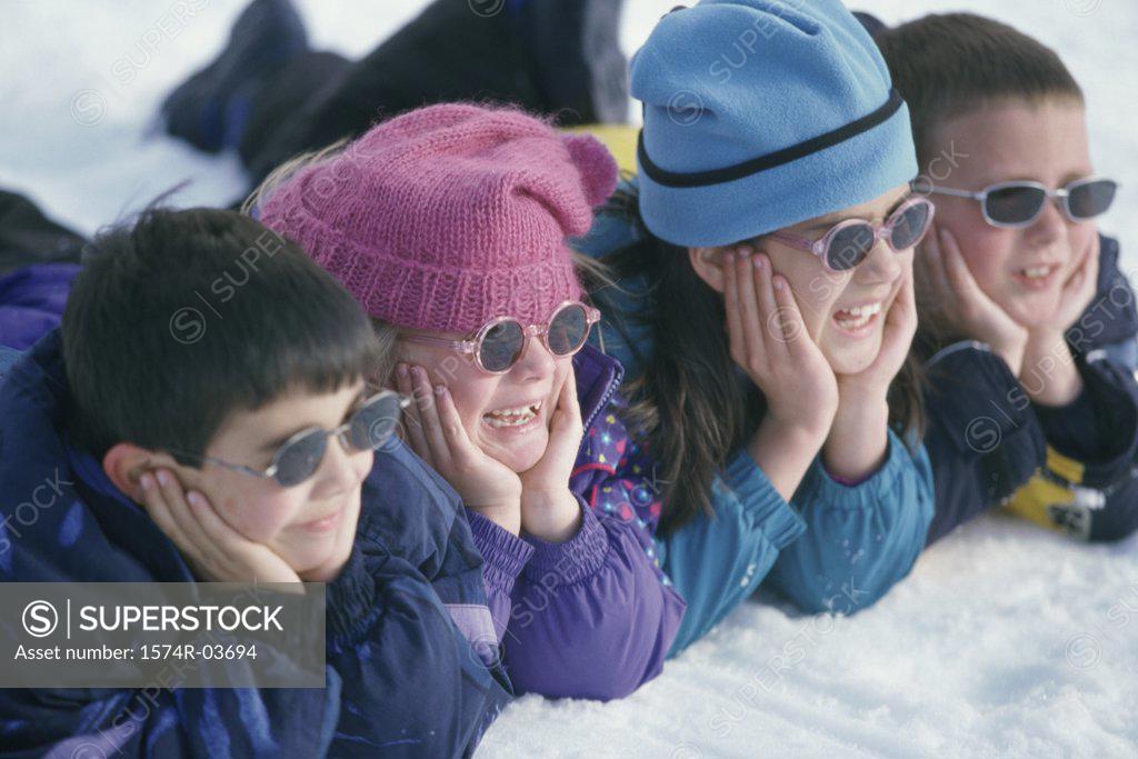 Stock Photo: 1574R-03694 Close-up of a group of children lying in snow