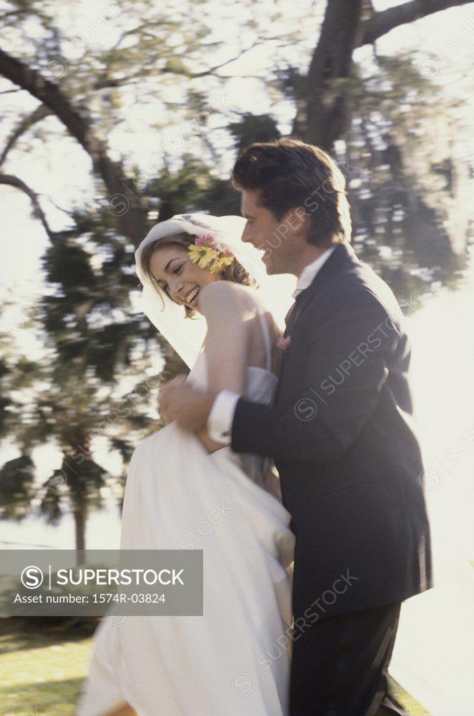 Stock Photo: 1574R-03824 Bride and groom embracing each other in a park