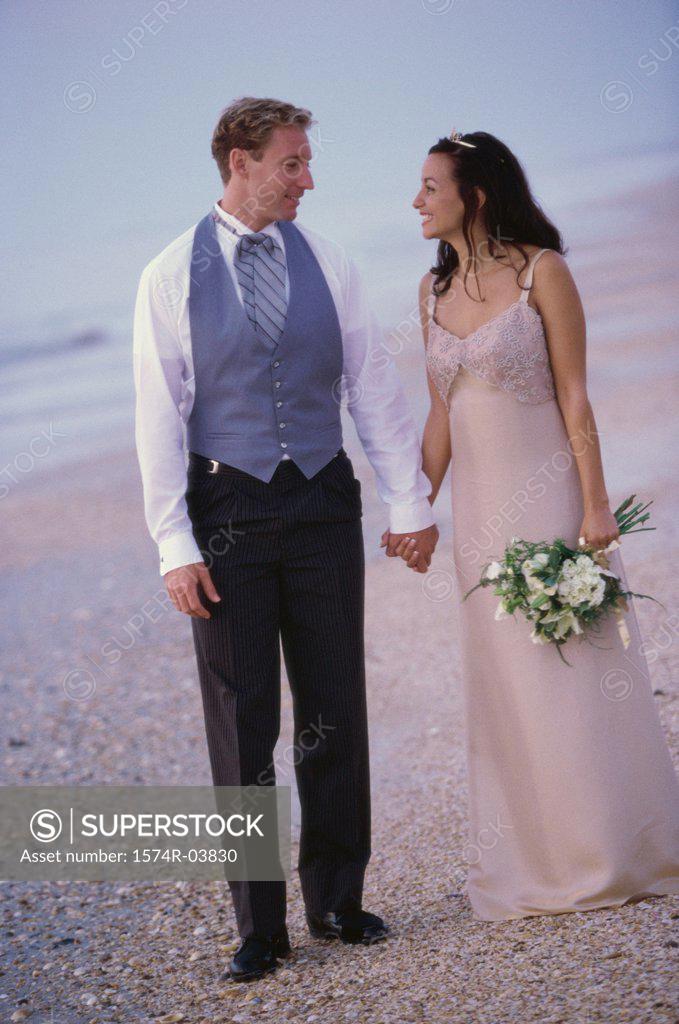 Stock Photo: 1574R-03830 Young couple standing together on the beach