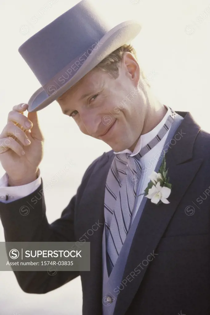 Portrait of a groom wearing a hat smiling