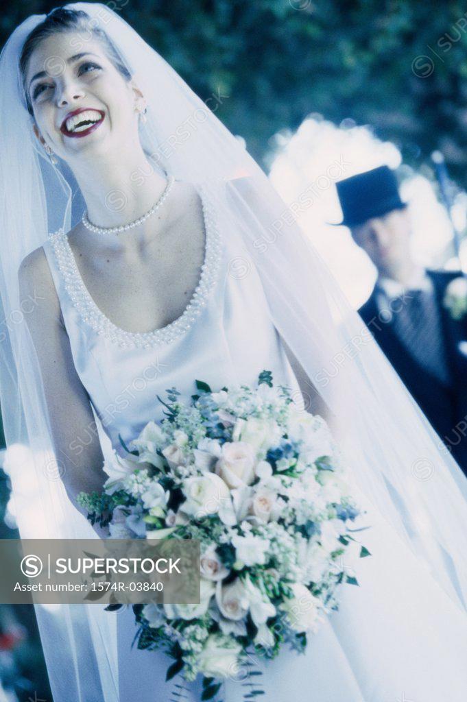 Stock Photo: 1574R-03840 Bride holding a bouquet of flowers smiling