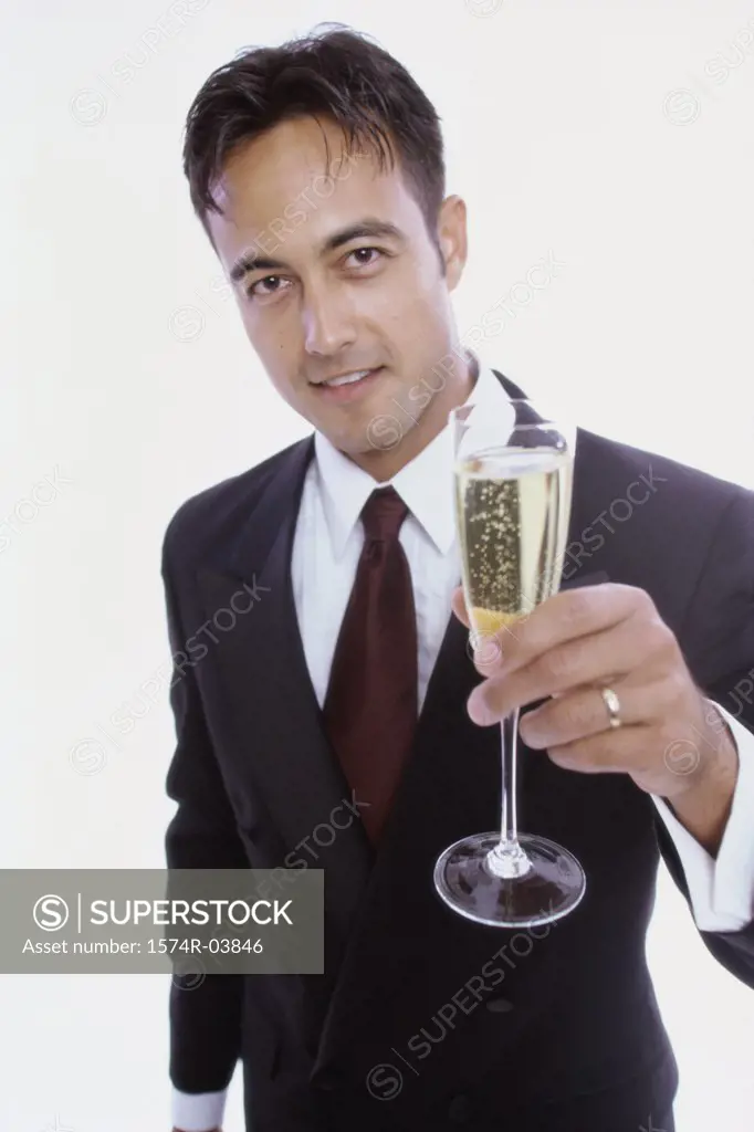 Portrait of a young man holding a glass of champagne