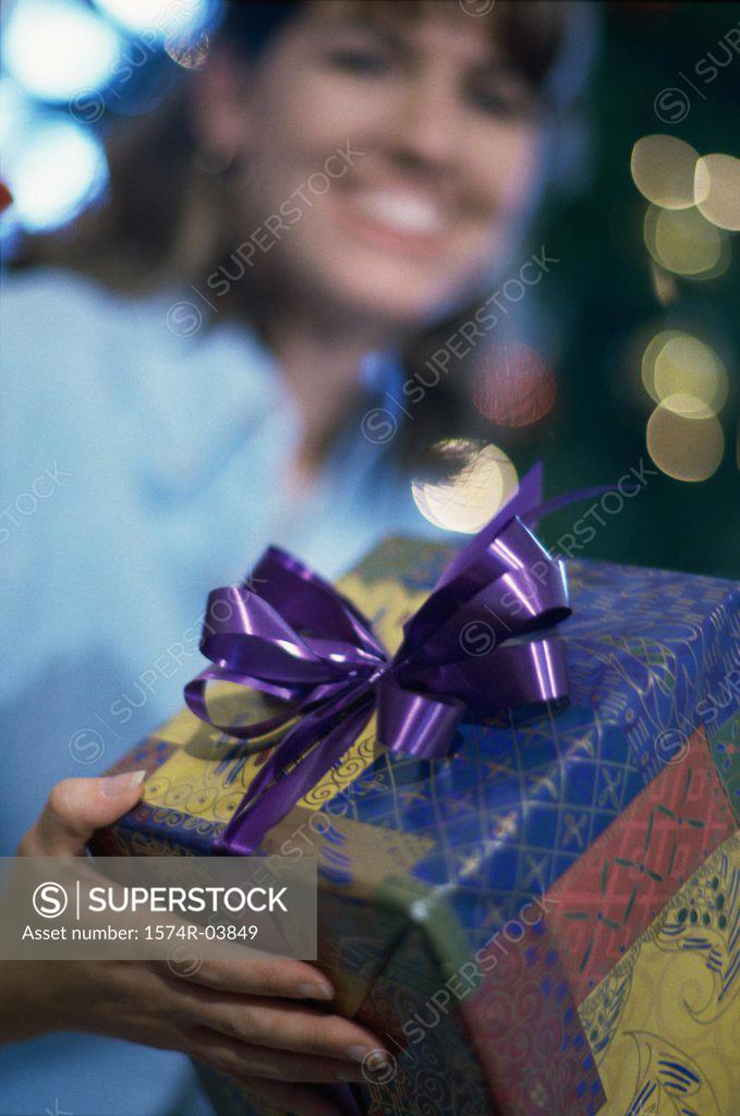 Stock Photo: 1574R-03849 Mid adult woman holding a gift smiling