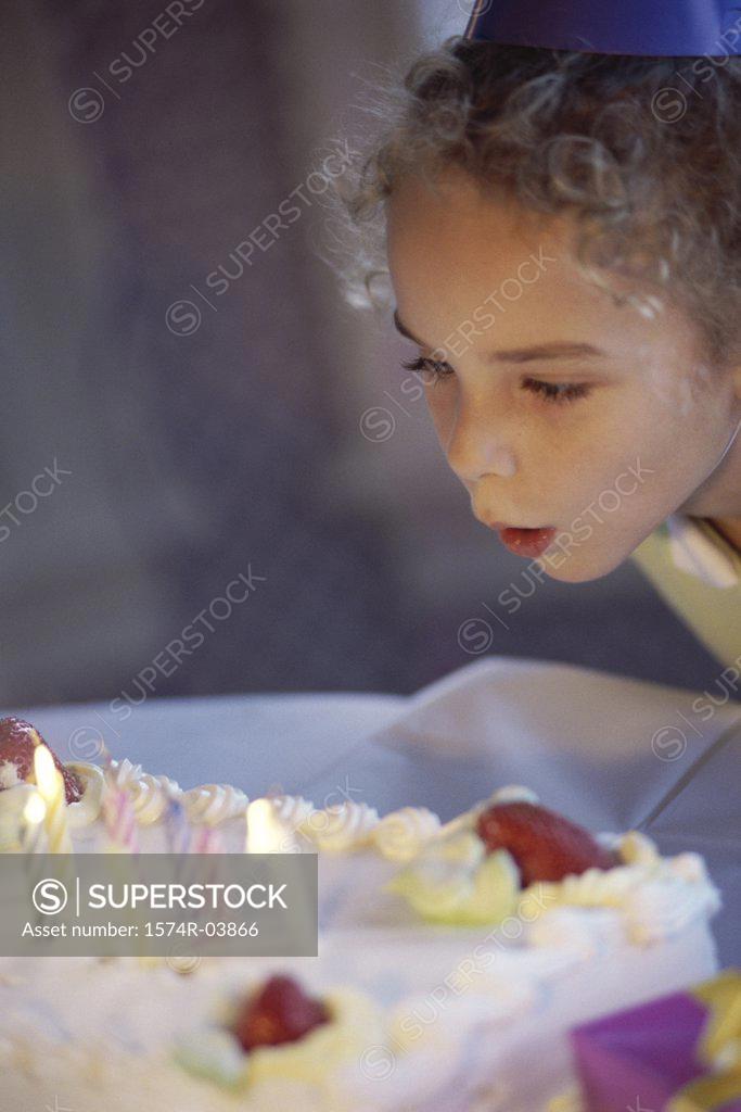 Stock Photo: 1574R-03866 Girl blowing candles on her birthday cake