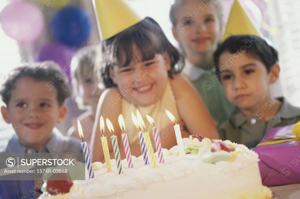 Stock Photo: 1574R-03868 Group of children in front of a birthday cake at a birthday party