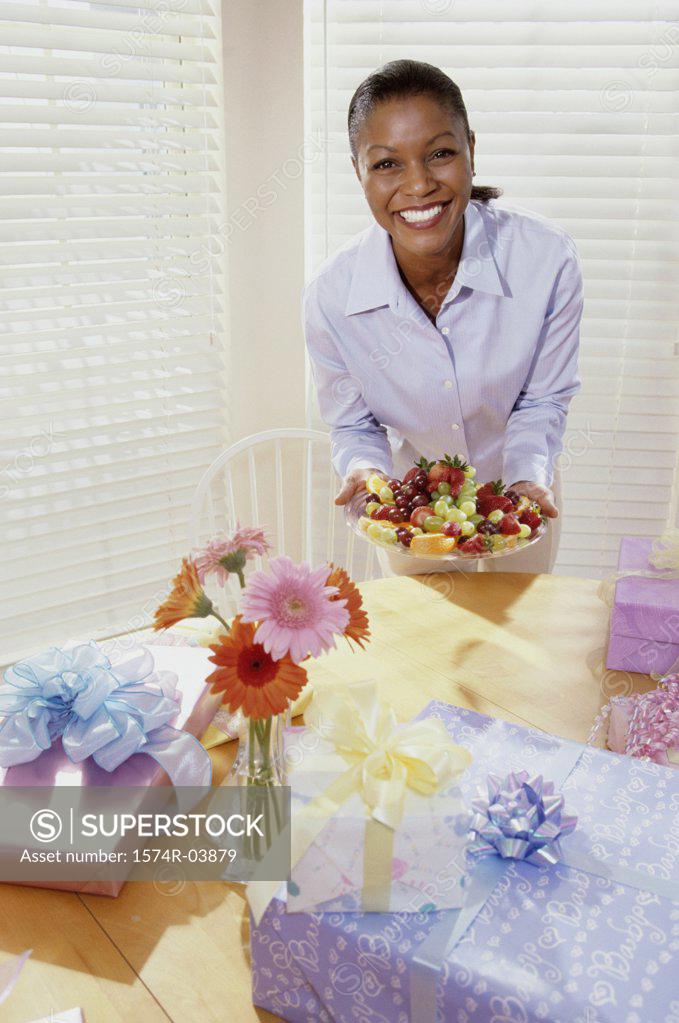 Stock Photo: 1574R-03879 Portrait of a young woman holding a plate of fruits