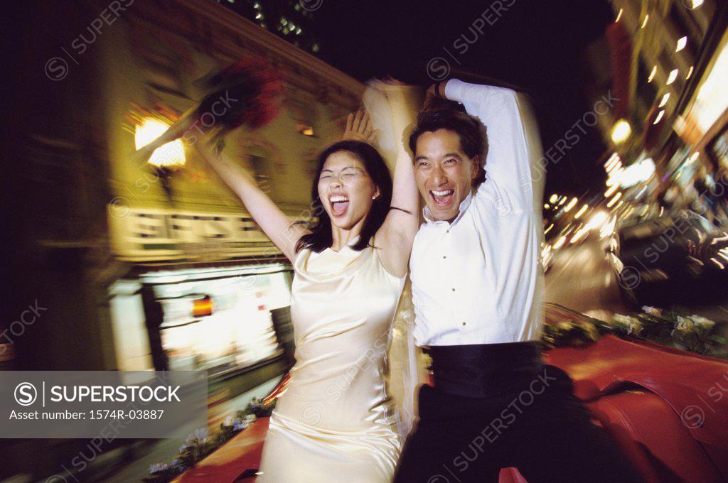 Stock Photo: 1574R-03887 Young couple sitting on the hood of a moving car