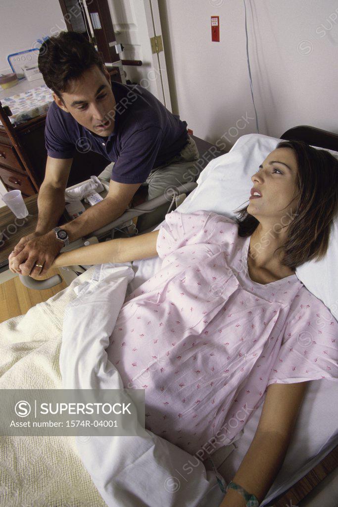 Stock Photo: 1574R-04001 Husband holding his pregnant wife's hand