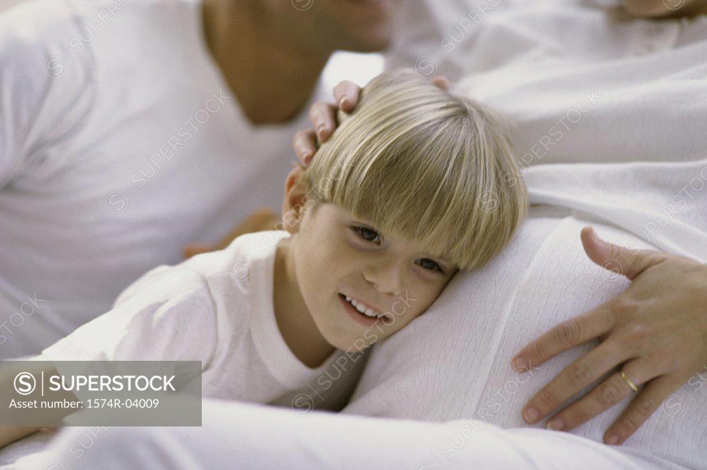 Stock Photo: 1574R-04009 Son with his head against his pregnant mother's abdomen