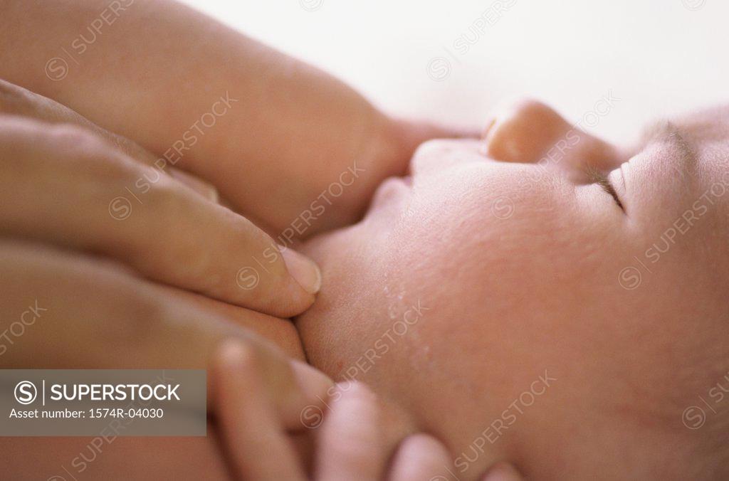 Stock Photo: 1574R-04030 Person's hand on a sleeping baby boy