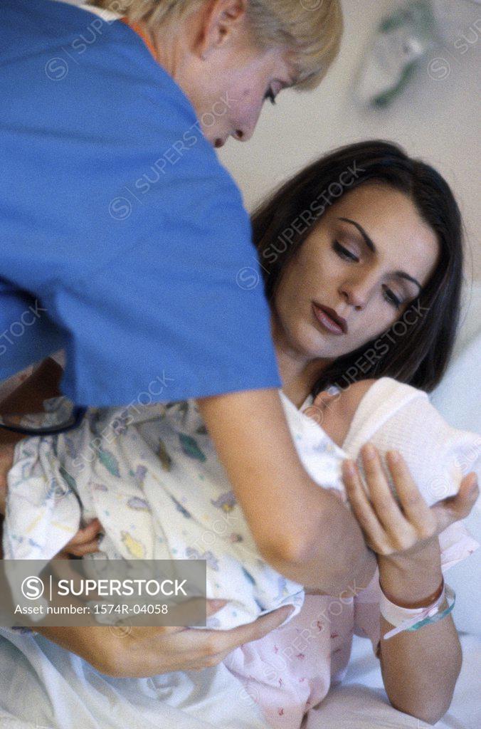 Stock Photo: 1574R-04058 Nurse giving a mother her baby girl