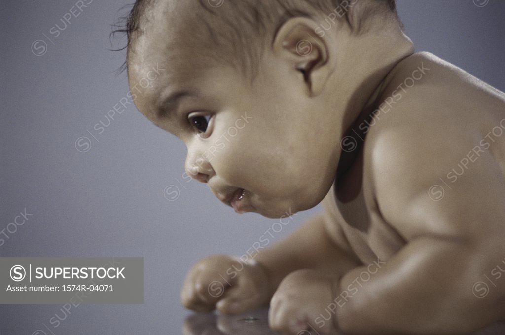Stock Photo: 1574R-04071 Side profile of a baby boy crawling