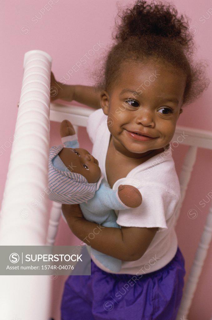 Stock Photo: 1574R-04076 High angle view of a baby girl holding a doll