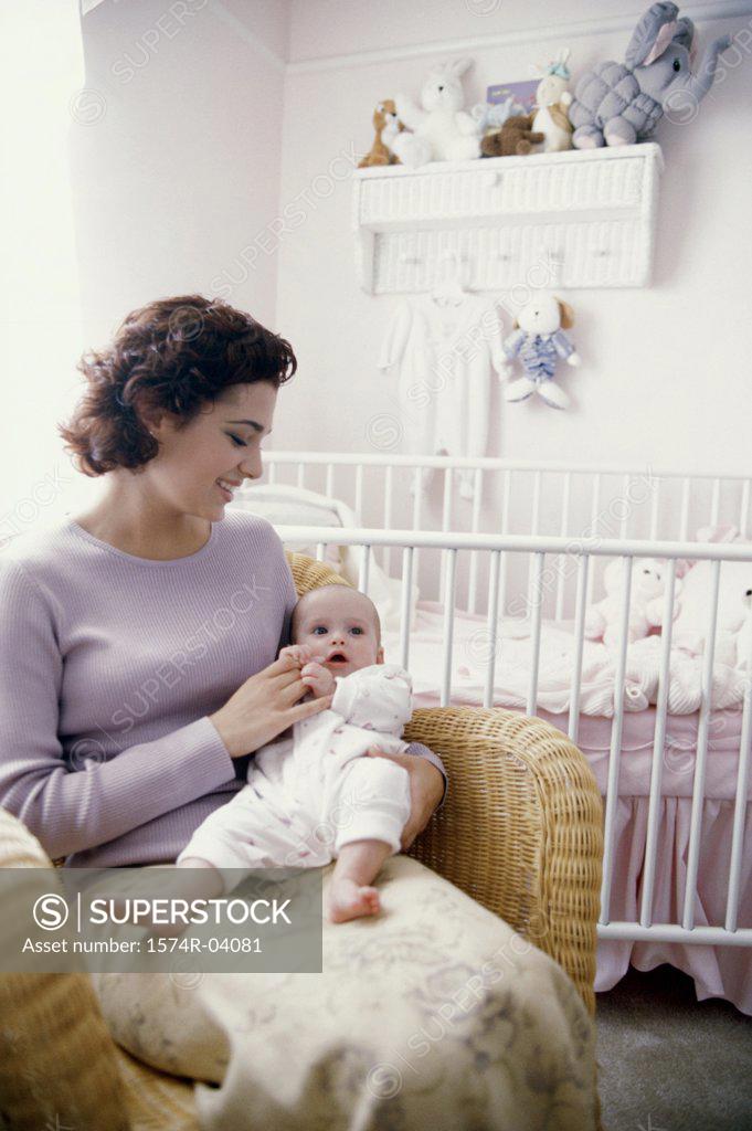 Stock Photo: 1574R-04081 Mother sitting with her baby boy in nursery
