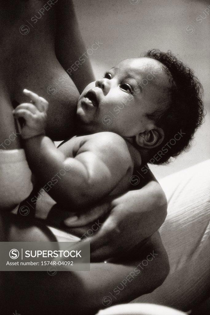 Stock Photo: 1574R-04092 Mid section view of a mother breastfeeding her baby boy