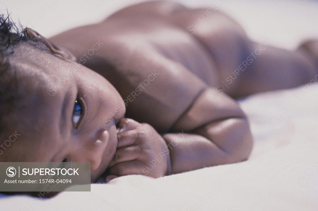 Stock Photo: 1574R-04094 Close-up of a baby boy lying on a bed