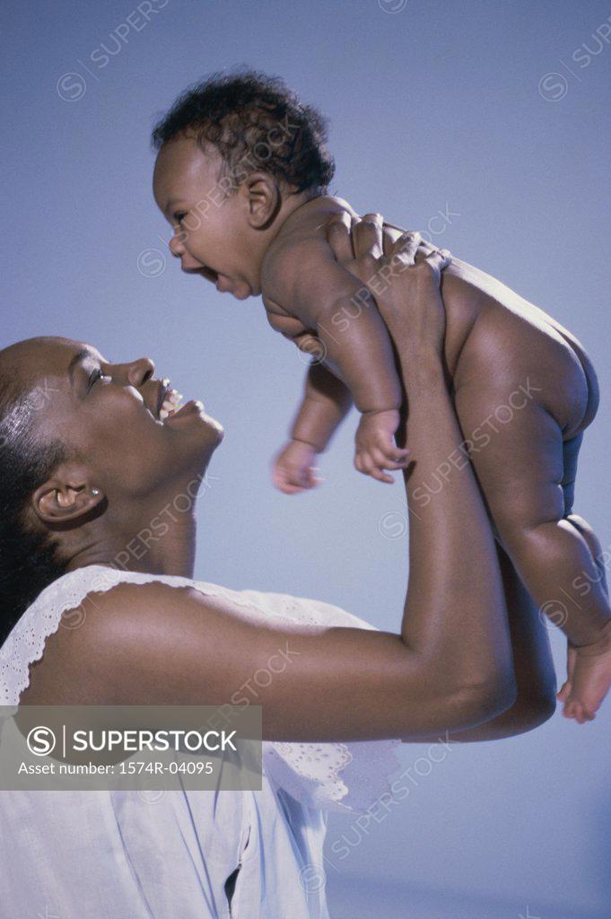 Stock Photo: 1574R-04095 Side profile of a mother playing with her baby boy