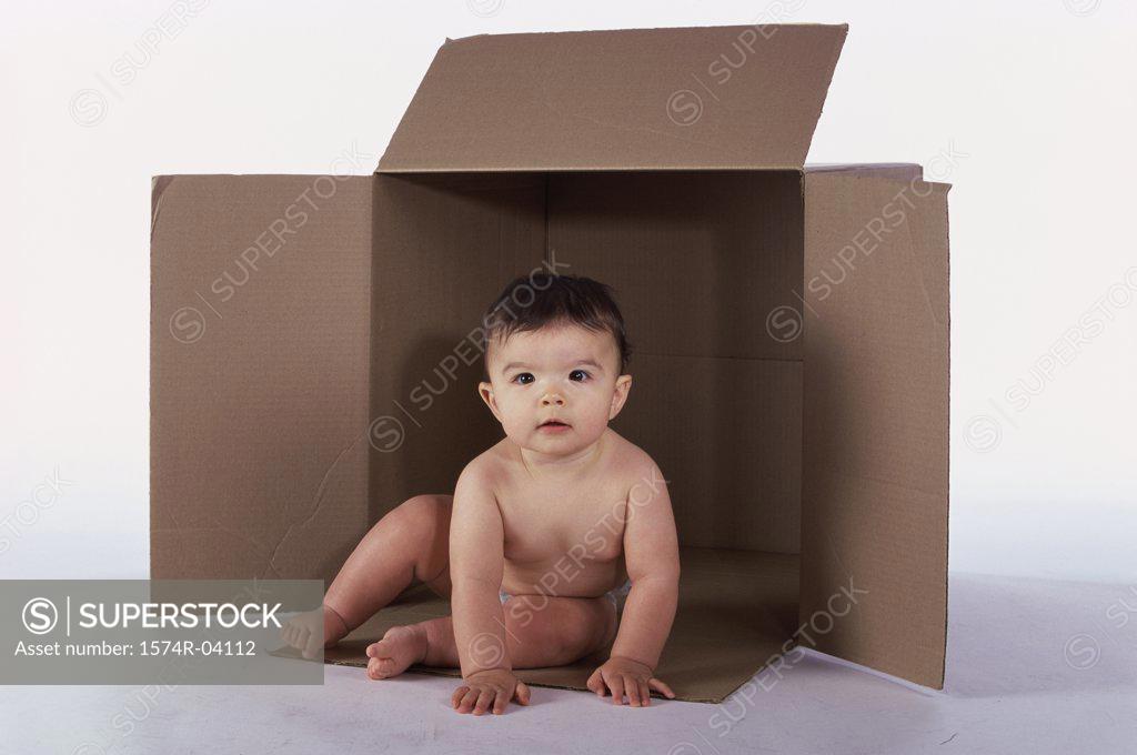 Stock Photo: 1574R-04112 Baby boy sitting in an empty cardboard box