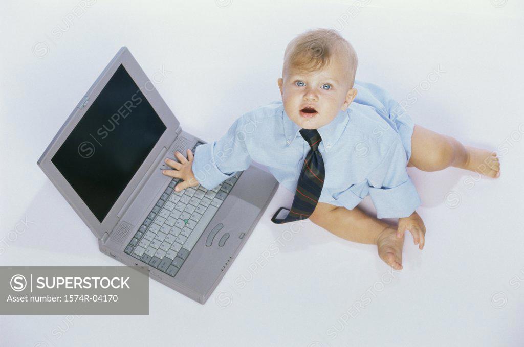 Stock Photo: 1574R-04170 Portrait of a baby boy touching a laptop