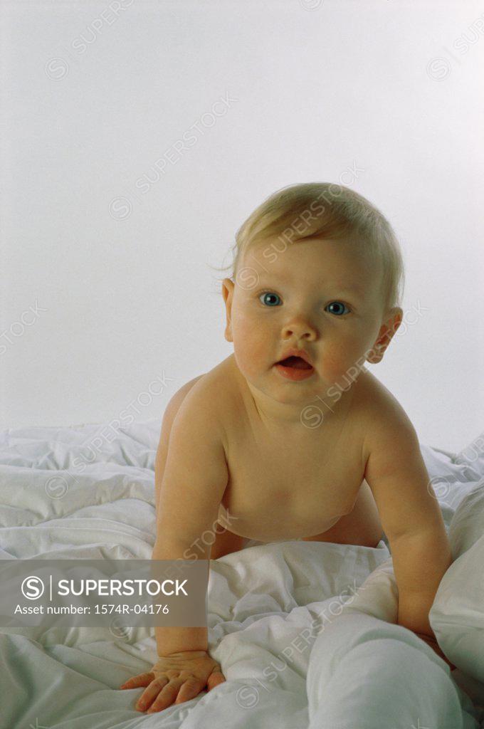 Stock Photo: 1574R-04176 Portrait of a baby boy crawling on a bed