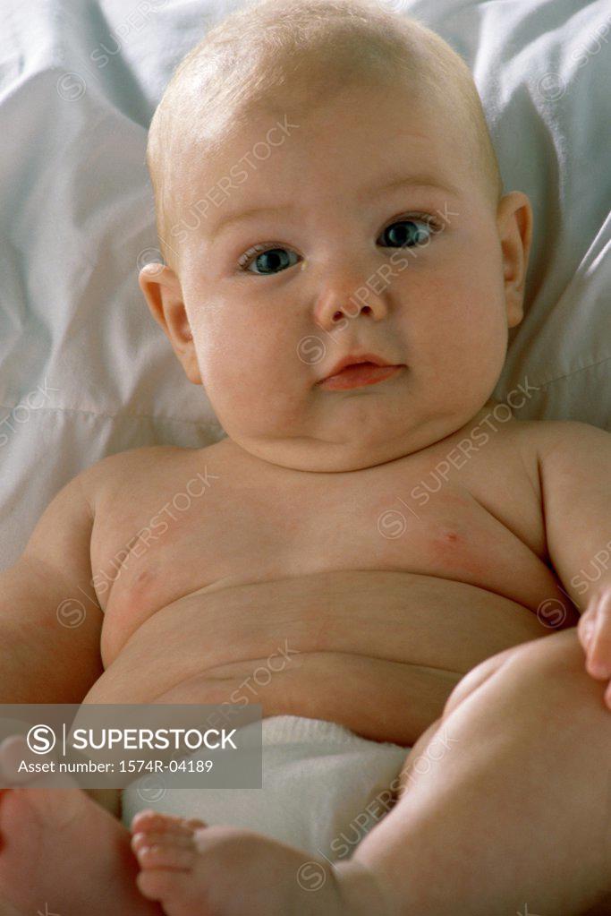 Stock Photo: 1574R-04189 Portrait of a baby boy lying on a bed