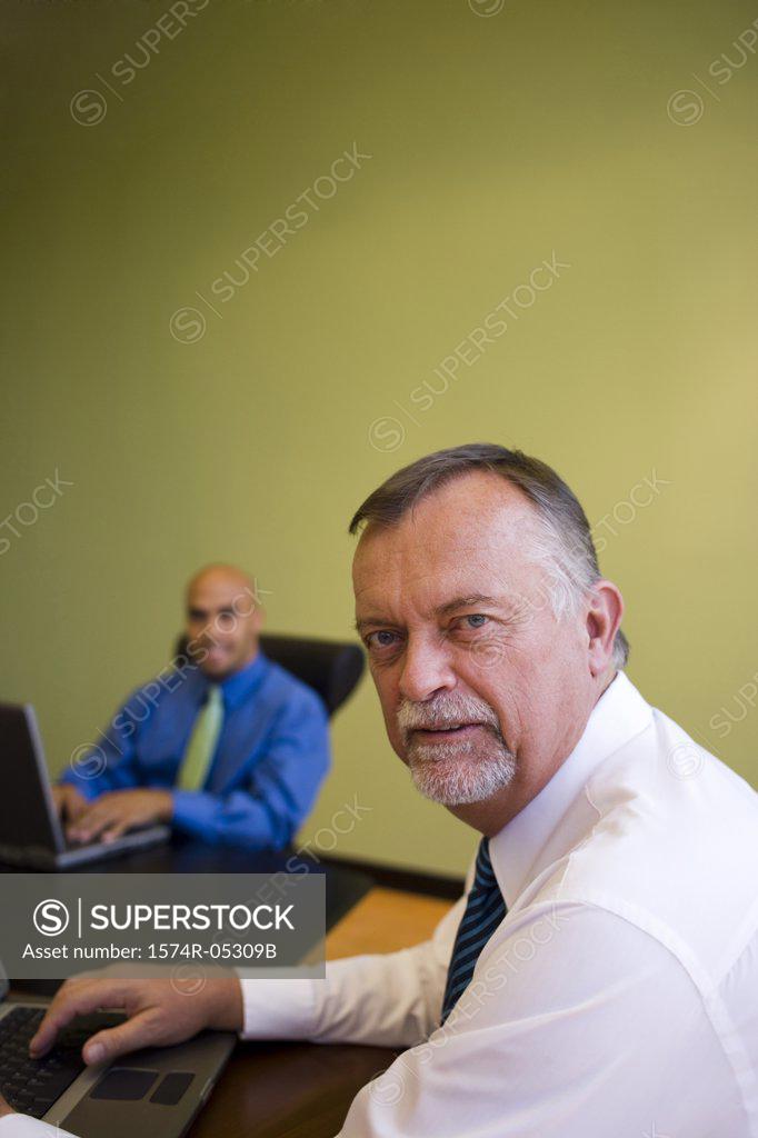 Stock Photo: 1574R-05309B Portrait of two businessmen sitting with laptops in a meeting