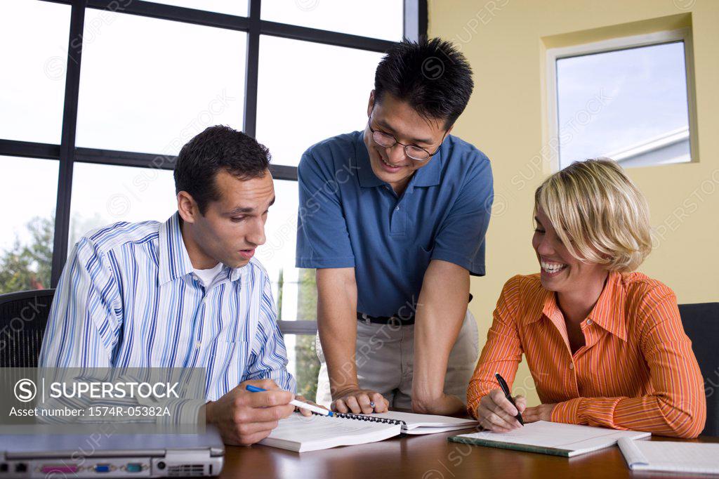 Stock Photo: 1574R-05382A Two businessmen and a businesswoman reading documents