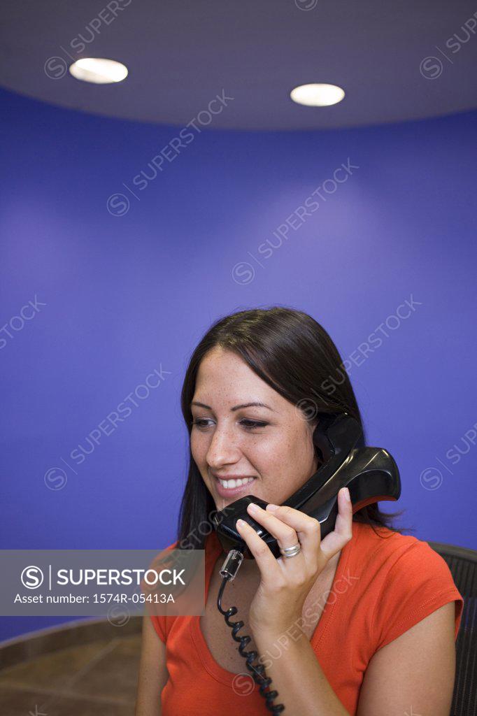 Stock Photo: 1574R-05413A Businesswoman talking on a telephone in an office